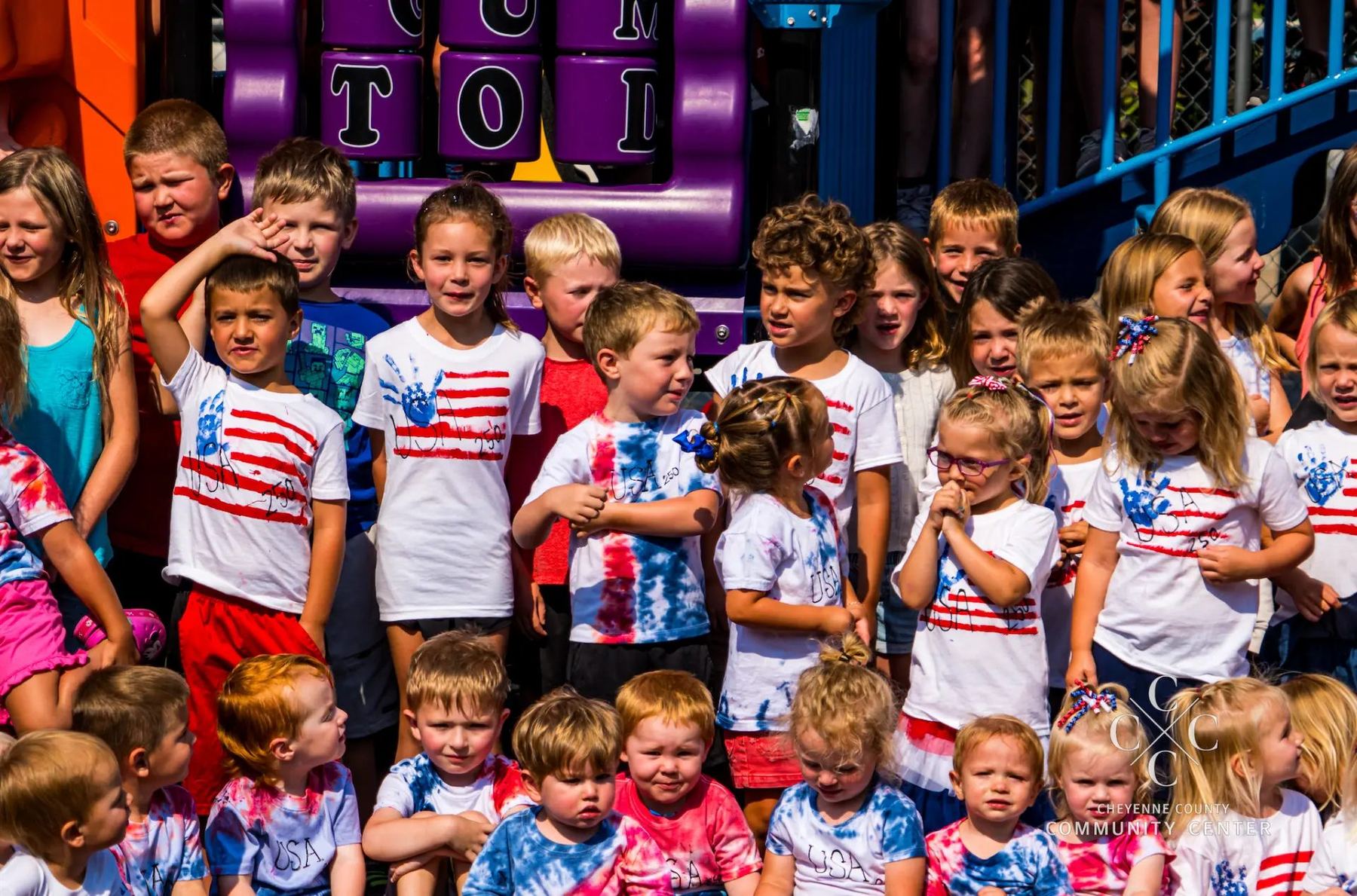 Children from Kids Korner gathered on the playground during the June 2026 Community Champion celebration.