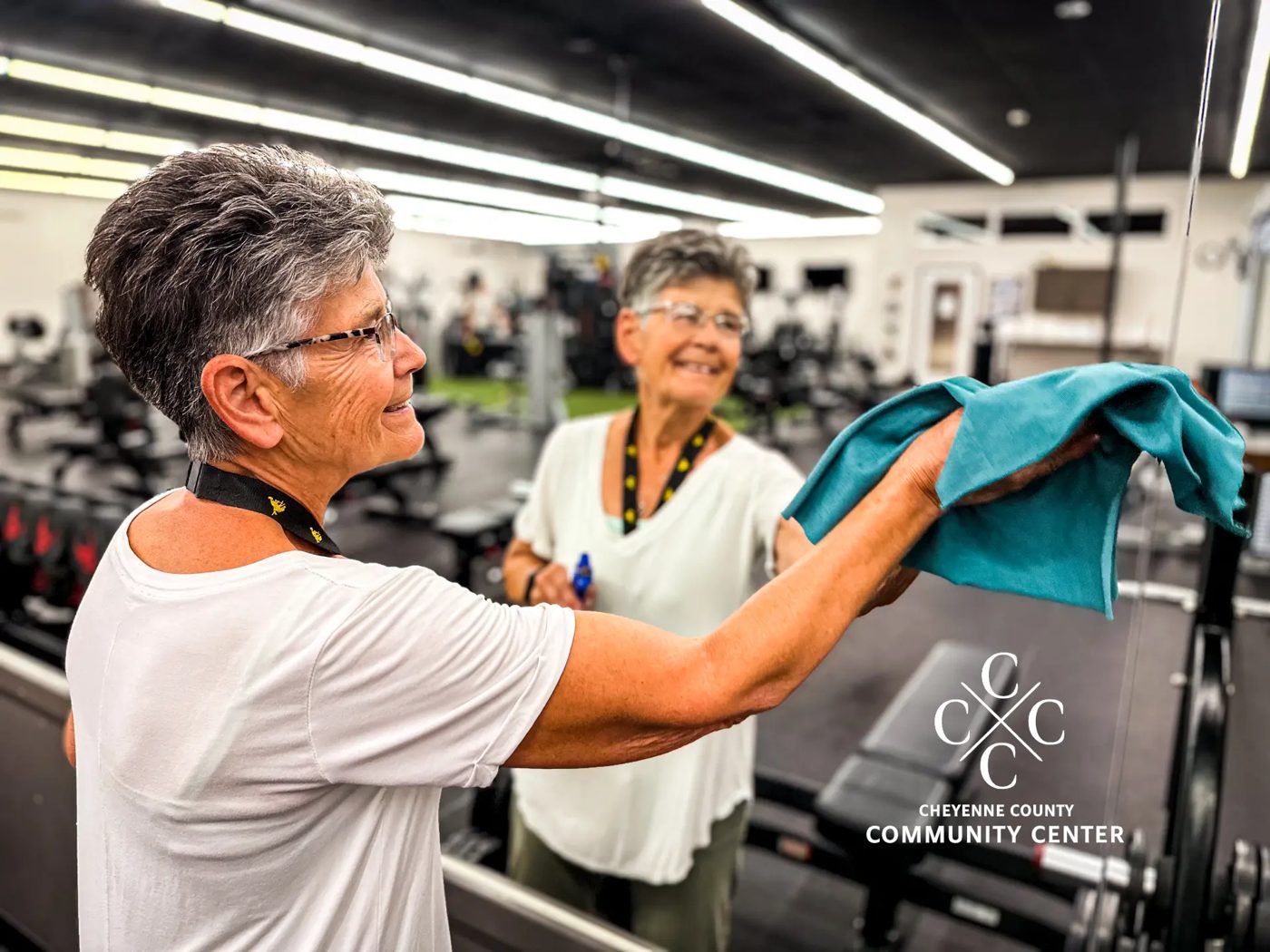 Val Kaup, Community Center Associate, wiping down equipment in the fitness center