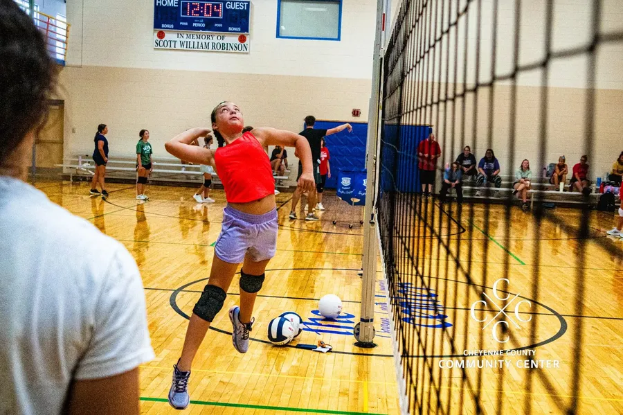 Youth volleyball player rising to attack the ball at the net during a camp session in the gym at The Center