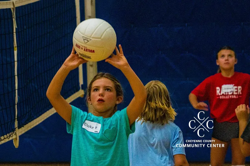 Young volleyball player setting the ball at the net during a youth volleyball session at The Center in Sidney, Nebraska